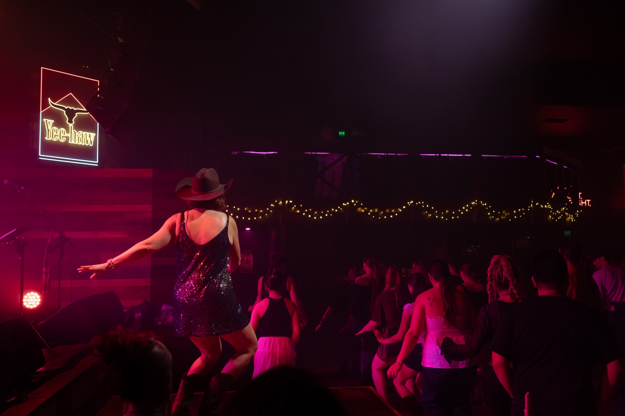 Claire teaching beside Gemma and the band under red stage lights